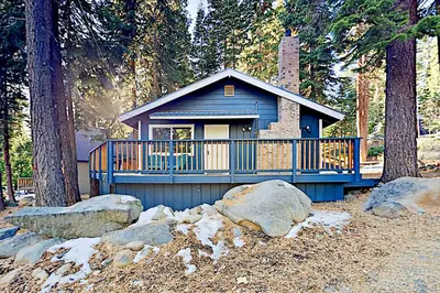 a small blue house in the middle of trees at Charming Lake Tahoe Cabin in Carnelian Bay