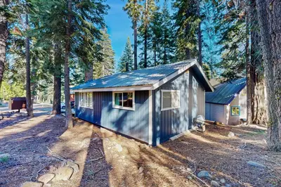 a blue tiny house in the middle of a forest at Charming Lake Tahoe Cabin in Carnelian Bay