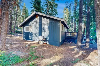 a blue shed in the middle of a forest at Charming Lake Tahoe Cabin in Carnelian Bay