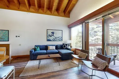 a living room with a blue couch and a table at Gold Bend Escape in Truckee