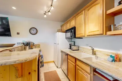 a kitchen with wooden cabinets and a white refrigerator at Coyote Fork 4051 in Truckee