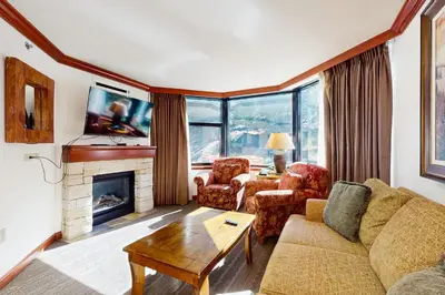 a living room with a couch and a fireplace at Resort at Squaw Creek's 319 in Olympic Valley