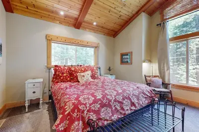 a bedroom with a bed with a red comforter at West Shore Retreat in Tahoma