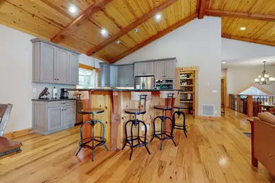 a kitchen with wooden floors and bar stools at West Shore Retreat in Tahoma