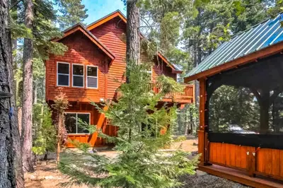 a log cabin in the woods with a garage at West Shore Retreat in Tahoma