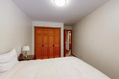 a bedroom with a white bed and a wooden door at Amazing Dollar Point Retreat in Tahoe City