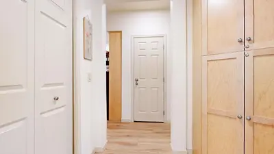 a hallway with white doors and wooden floors at Mammoth Green 118 Located on Sierra Star Golf Course, Private Patio, Summer Pool condo in Mammoth Lakes