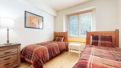 a bedroom with two beds and a window at Mammoth Green 118 Located on Sierra Star Golf Course, Private Patio, Summer Pool condo in Mammoth Lakes