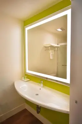 a bathroom with a sink and a large mirror at Foothills Motel in Auburn