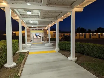 a covered walkway leading to a building at night at Foothills Motel in Auburn