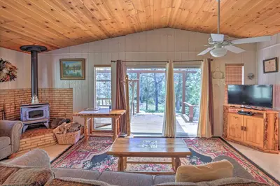 a living room with a couch and a table at Gorgeous Oakhurst Retreat with Swimming Hole! in Oakhurst