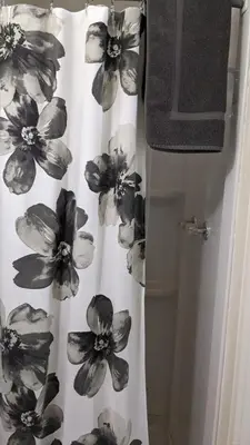 a shower curtain with flowers on it in a bathroom at Room #3 at the Apple Place in Miramonte