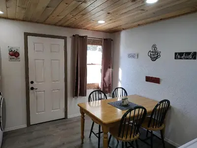 a dining room with a wooden table and chairs at Gilmore Cabin in Miramonte