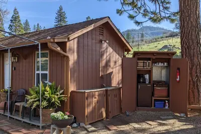 a large brown shed with a kitchen and a tree at The Apple Place Room #2 in Miramonte