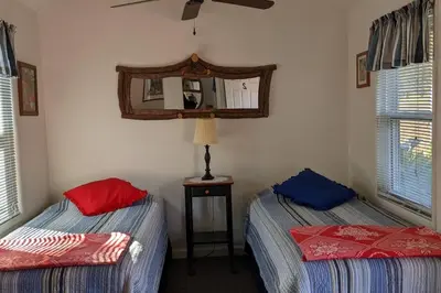 a bedroom with two beds and a mirror on the wall at The Apple Place Room #2 in Miramonte