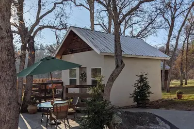 a small house with a table and an umbrella at Sweet Mountain Cabin in Squaw Valley