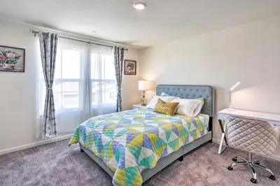 a bedroom with a bed with a colorful comforter and a window at Sacramento Retreat with Yard about 13 Mi to Dtwn! in Elk Grove
