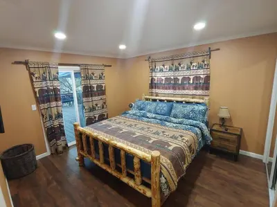 a bedroom with a large bed with a wooden headboard at Mountain Cabin near Yosemite in Groveland