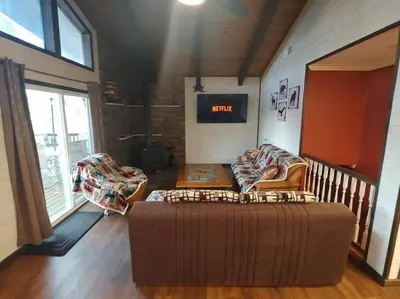 a living room with a couch and a ottoman at Mountain Cabin near Yosemite in Groveland