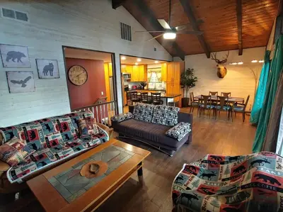 a living room with couches and a table and a dining room at Mountain Cabin near Yosemite in Groveland
