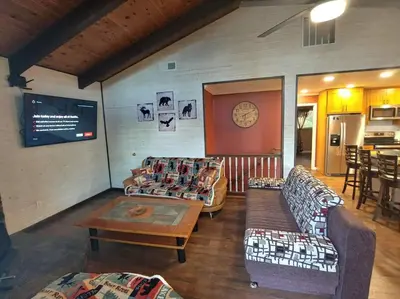 a living room with couches and a clock on the wall at Mountain Cabin near Yosemite in Groveland