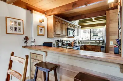 a kitchen with a large wooden bar in a room at Mill Camp Gem in Ponderosa Fairway Estates