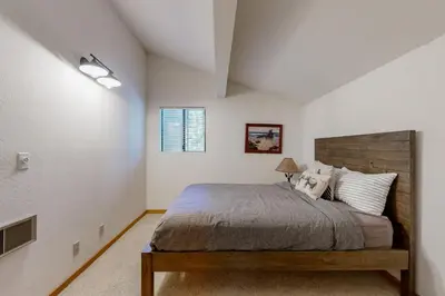 a bedroom with a large bed with a wooden headboard at Snowpeak Oasis in Truckee