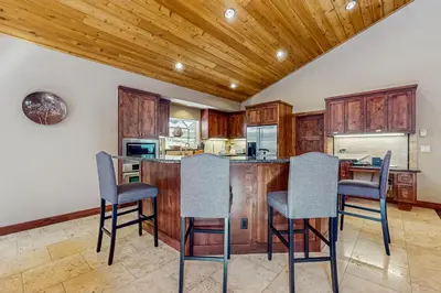 a kitchen with wooden cabinets and bar stools at Miztec Charms in South Lake Tahoe