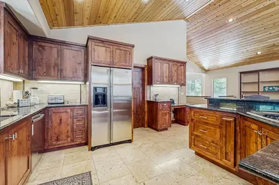 a kitchen with wooden cabinets and a stainless steel refrigerator at Miztec Charms in South Lake Tahoe