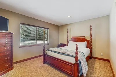 a bedroom with a bed and a dresser and a window at Miztec Charms in South Lake Tahoe