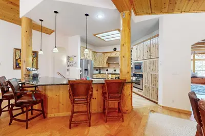 a kitchen with wooden cabinets and a table and chairs at Wooded Luxury at Tahoe Donner in Truckee