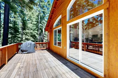a wooden porch of a cabin with a large window at Tyrol Getaway in Truckee