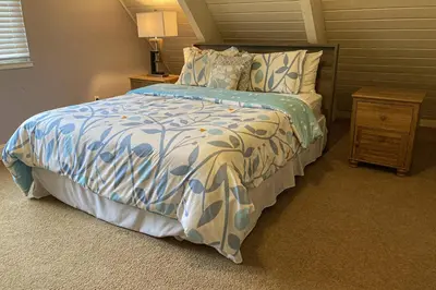 a bedroom with a bed with a blue and white comforter at Cougar Haven in South Lake Tahoe