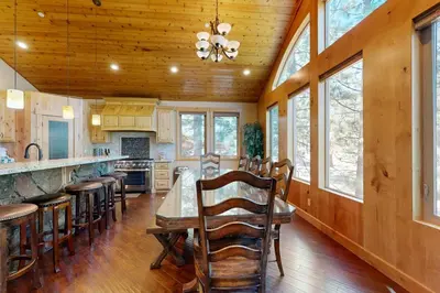 a kitchen with a table and chairs and windows at Marshall Escape in South Lake Tahoe