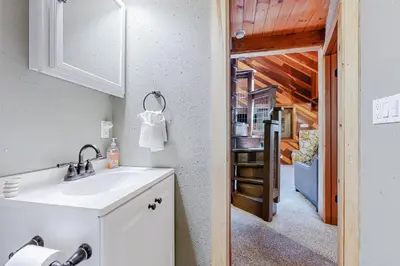a kitchen with a sink and a door to a room at Cabin Oasis in Tahoma