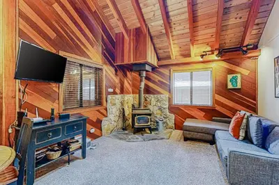 a living room with a stone fireplace and a tv at Cabin Oasis in Tahoma