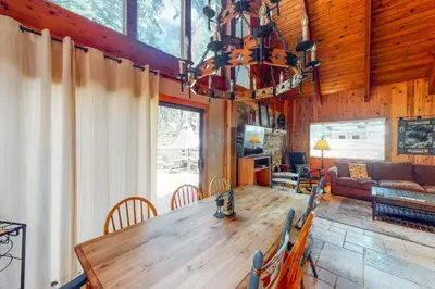 a dining room and living room with a large wooden table at Tahoe Pines Cabin in Homewood