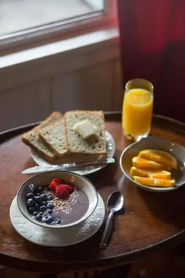 a table with two plates of breakfast foods and a glass of orange juice at Quiet Mind Lodge, Spa & Retreat Sequoias in Kernville