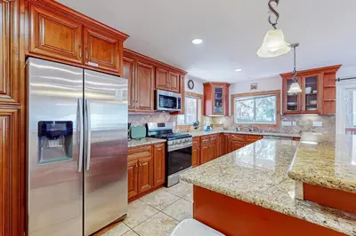 a kitchen with wooden cabinets and a stainless steel refrigerator at Lone Indian Charms in South Lake Tahoe