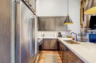 a kitchen with wooden cabinets and a stainless steel refrigerator at Ski-In, Ski-Out Designer Condo in Truckee