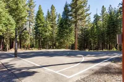 an empty basketball court with trees in the background at Ski-In, Ski-Out Designer Condo in Truckee