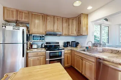 a kitchen with wooden cabinets and a stainless steel refrigerator at Ski Bowl Condos Unit 518 in Truckee