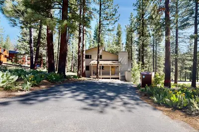 a house in the woods with a driveway at Northstar Home in Truckee