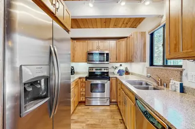 a kitchen with wooden cabinets and stainless steel appliances at Northstar Home in Truckee