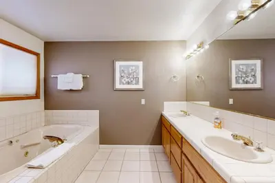 a bathroom with two sinks and a tub and a mirror at High Meadow Storybook in South Lake Tahoe