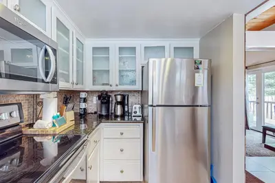 a kitchen with a stainless steel refrigerator and white cabinets at Montgomery Estates Retreat in South Lake Tahoe
