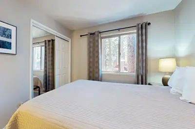 a bedroom with a large white bed and a window at Cellador Charms in South Lake Tahoe