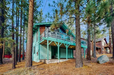a house with a wrap around deck in the woods at Donner Escape in South Lake Tahoe