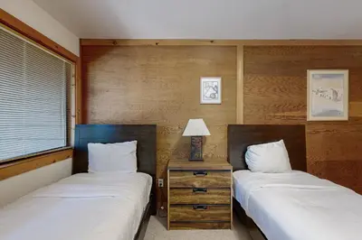 two twin beds in a room with a nightstand between them at Rocky Point Charms in Truckee