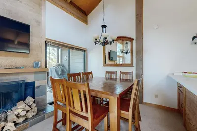 a dining room with a table and a fireplace at Rocky Point Charms in Truckee